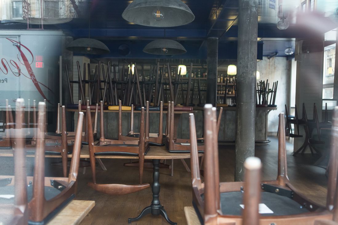 Chairs stacked on tables inside an empty bar